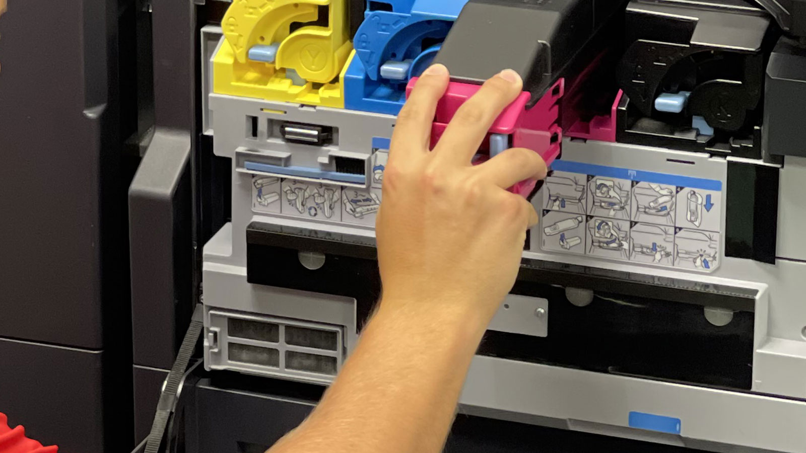Someone removing a magenta toner cartridge out of a KYOCERA copier